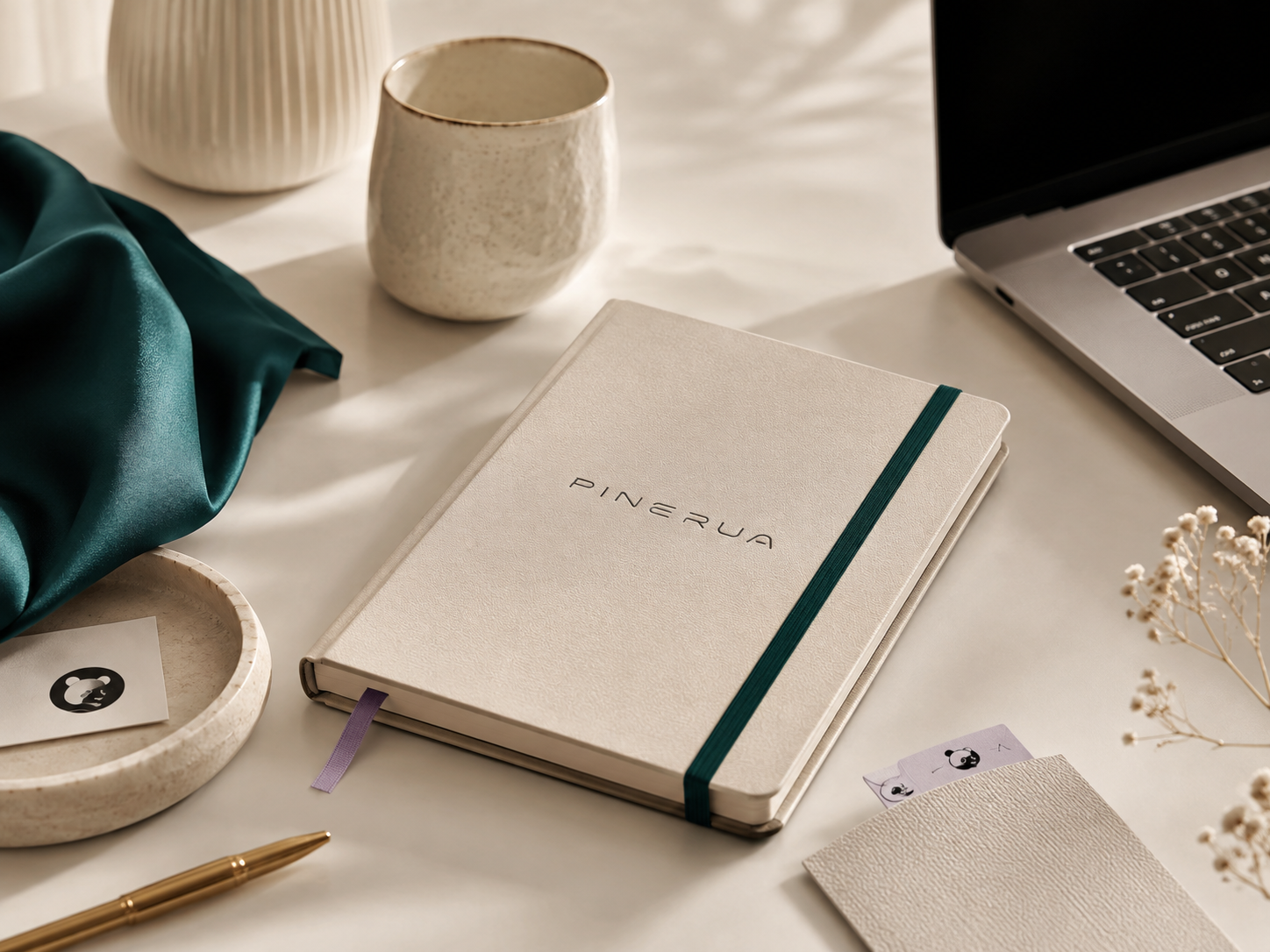 It's Pinerua branded workspace with notebook, ceramics, and teal fabric